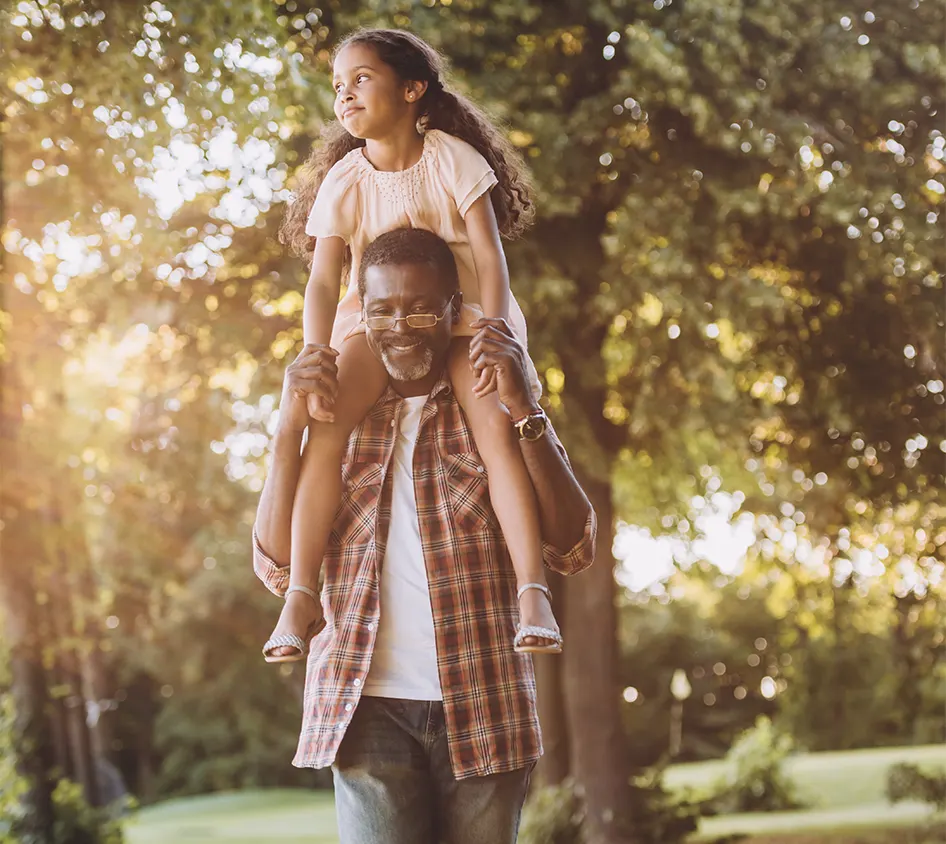 granddaughter on her grandpas shoulders outside on a nice day successful retirement future