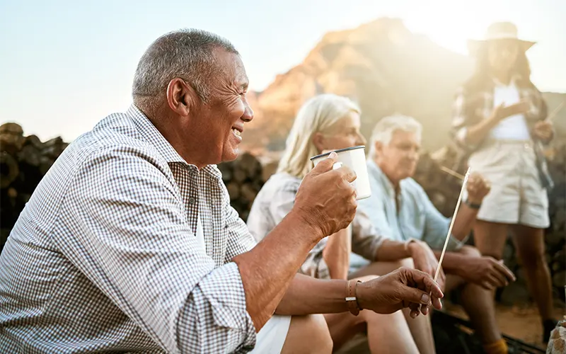 group of senior friends by camp fire on hiking trip three core principles