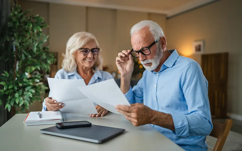 senior couple reviewing finances at their table reasonable rate of return in retirement